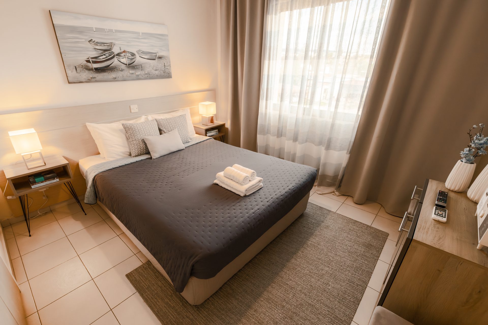 Bedroom with queen bed and harbour painting